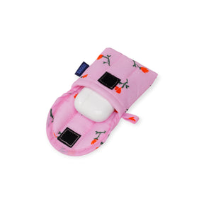 The Baggu Puffy Earbuds Case - Painted Wildflower holds a white wireless earbud case. This pink floral case by Baggu features a black Velcro closure and is shown on a white background.