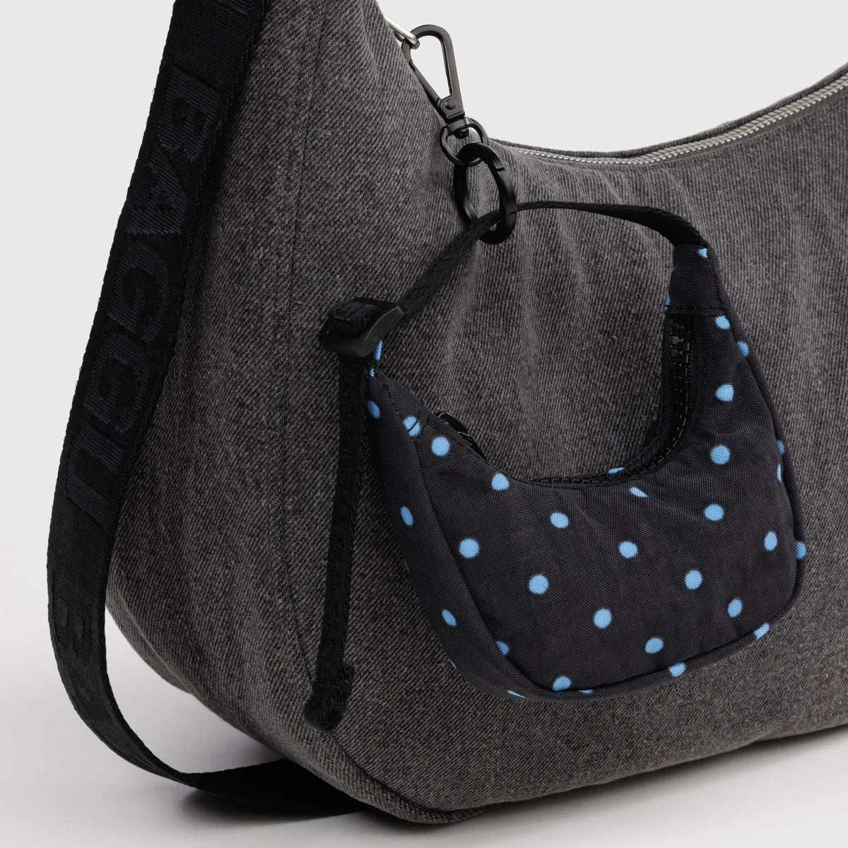 Crescent bag charm pouch with blue micro dots on black, secured with clasp