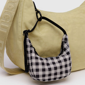 Black and white gingham Baggu Crescent bag charm clipped to beige bag strap, gallery image 1, baggu_crescent-bag-charm_bw-gingham_02.webp