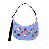 The Hello Kitty x Baggu Medium Nylon Crescent Bag by Baggu is a blue handbag featuring delightful cartoon cat faces, strawberries, apples, and flowers, along with a sleek black strap.