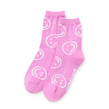 Pair of pink ankle socks decorated with large white smiley faces against a plain white background