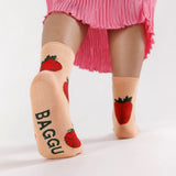 A person wearing Baggu Crew Sock - Strawberry by Baggu, with strawberry designs and a hint of bamboo rayon, paired perfectly with a pink pleated skirt creates ultimate strawberry vibes.