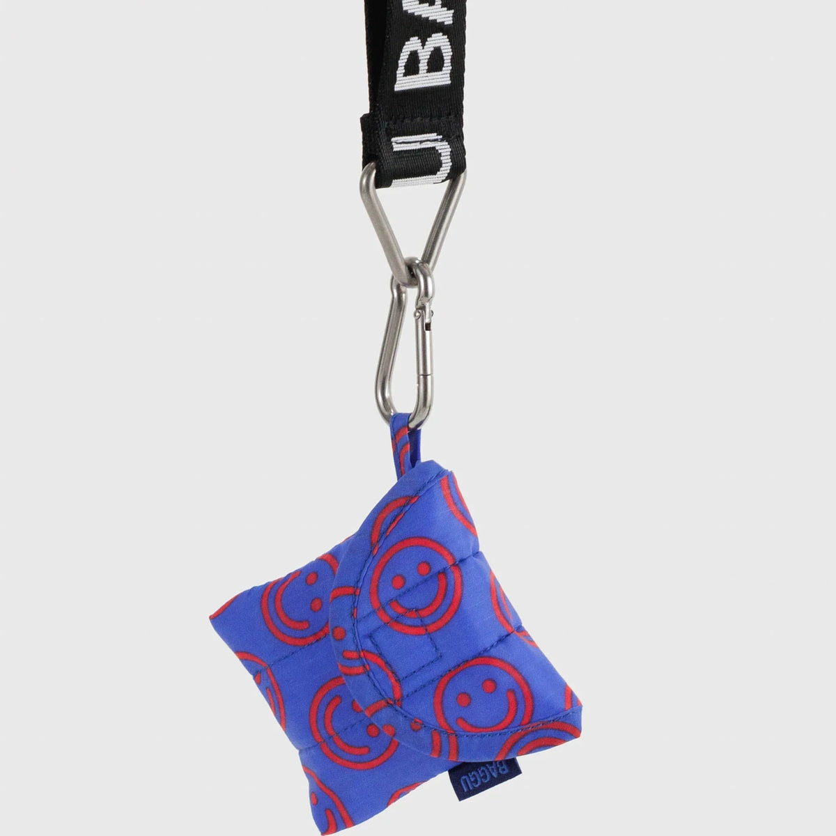 Baggu mini puffy earbuds case in cobalt blue with smiley circles; keychain clip