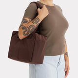 Brown canvas tote bag with flat handles and structured side gussets