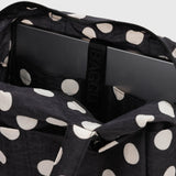 Interior of black polka-dot tote with zip top, padded lining and inner pockets