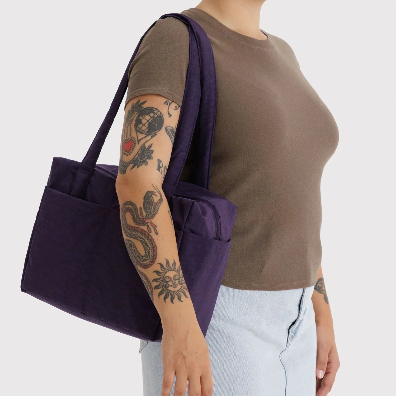Baggu cloud tote in fig purple, carried on shoulder with wide straps