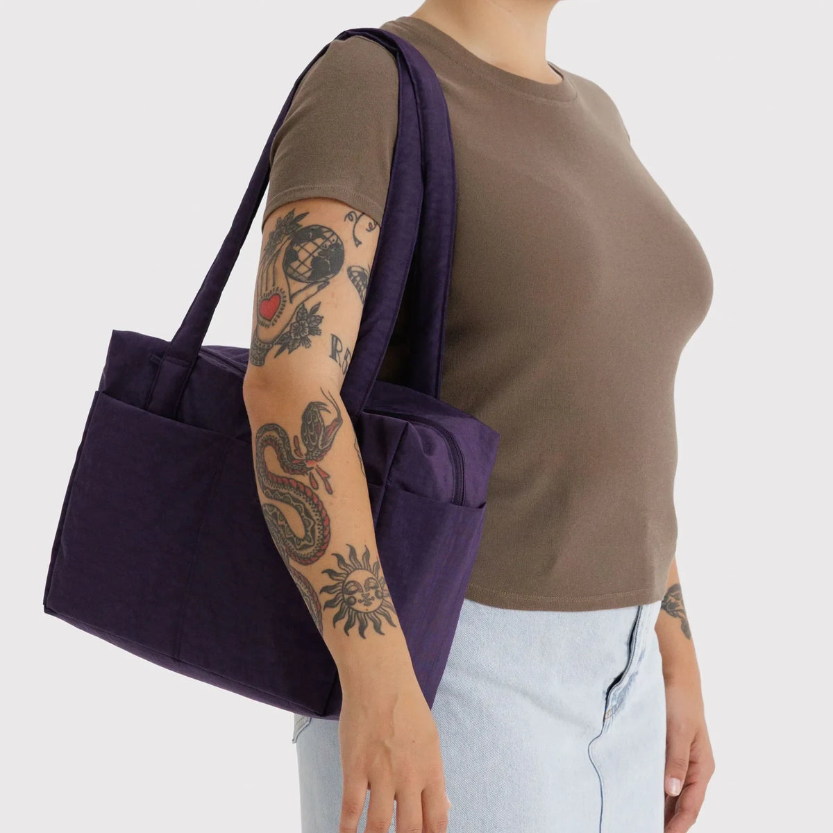 Baggu cloud tote in fig purple, carried on shoulder with wide straps
