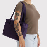 Baggu cloud tote in fig purple, carried on shoulder with wide straps