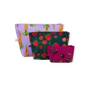 Set of three fabric zipper pouches featuring carrot, strawberry, and cherry patterns on purple, dark green, and magenta backgrounds