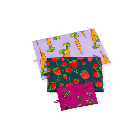 Three fabric zipper pouches with carrot, strawberry, and cherry prints in purple, green, and magenta backgrounds