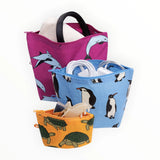 Stacked pouches with penguin and dolphin prints; magenta, blue, orange zip pouches