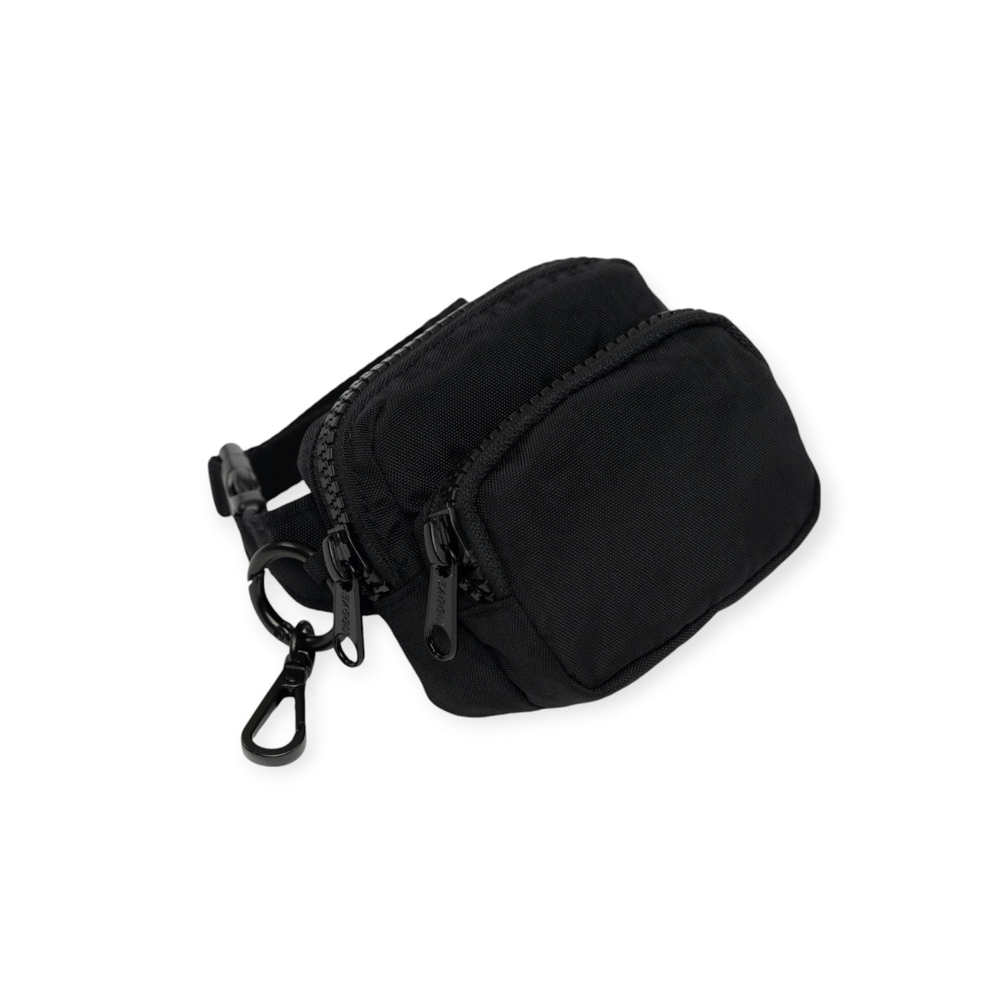 The Baggu Fanny Pack Charm by Baggu is a sleek black pouch made from recycled heavyweight nylon, featuring two zippered compartments and a metal clip. It serves as a stylish fanny pack bag charm or chic keychain accessory, merging functionality with eco-friendly fashion.