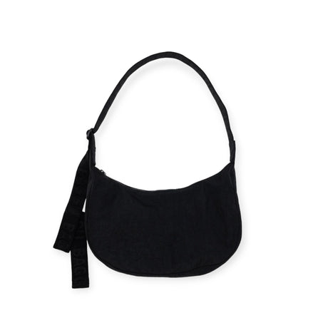 The Baggu Medium Nylon Crescent Bag - Black by Baggu provides a sleek, minimalist design with its rounded shape and striking text-adorned strap. Additionally, the adjustable strap allows for comfortable all-day wear.