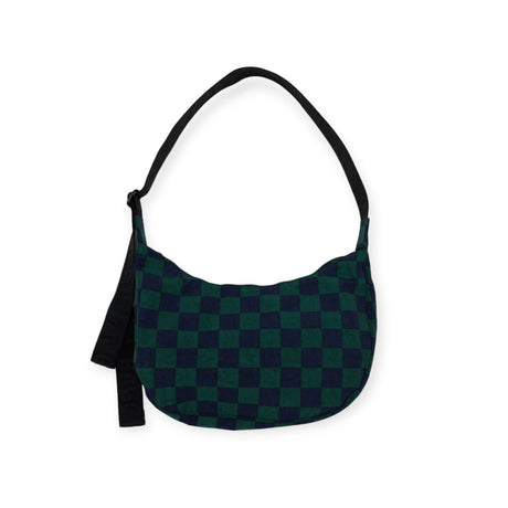 The Baggu Medium Nylon Crescent Bag in Navy Green Check from Baggu, with its sleek black strap and side tassel, exudes retro-cool vibes.