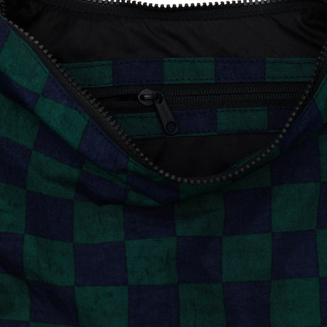 A close-up of a partially open zipper on the Baggu Medium Nylon Crescent in navy green check pattern, exuding retro-cool vibes.