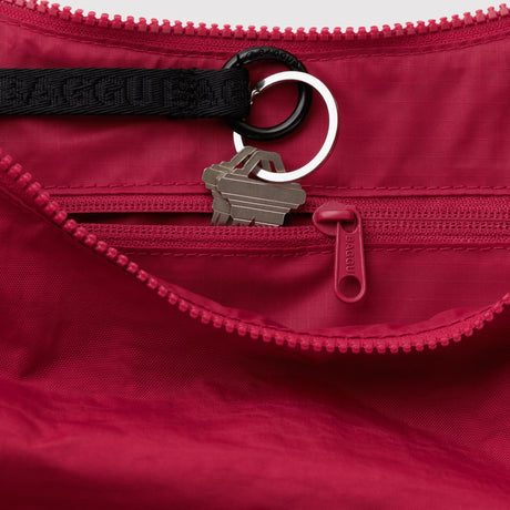 Red nylon crescent bag interior with zipper, key ring, and toggle loop