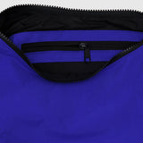 Close-up of an open Baggu Medium Nylon Crescent Bag - Lapis Blue by Baggu, highlighting a visible black zipper pocket made from recycled nylon.