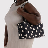Medium nylon bowler bag with cream polka dots, held by top handles
