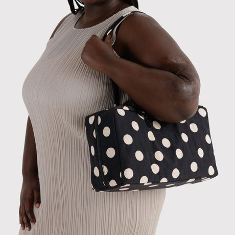 Medium nylon bowler bag with cream polka dots, held by top handles