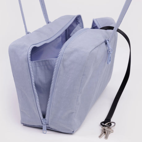 Light blue rectangular fabric crossbody bag with dual zipper compartments and detachable black key strap holding metal keys