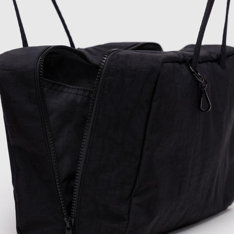 A close-up of the Baggu Medium Nylon Bowler Bag - Black by Baggu, crafted from recycled nylon with long straps and a partially open zipper, set against a plain background.