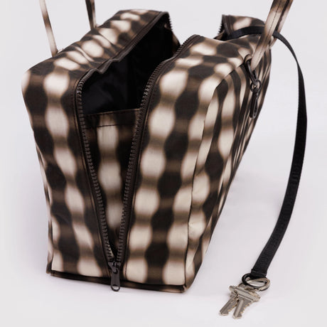 Rectangular handbag with black and beige wavy striped pattern and open dual zipper compartments on white background