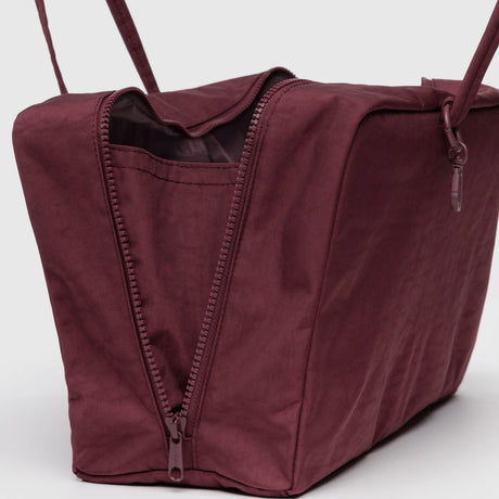 Mahogany medium-sized Baggu nylon bowler bag with partially open zipper showing interior pocket and long straps