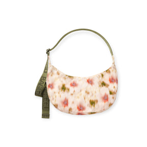 Oval-shaped fabric handbag with orange, green, and beige abstract pattern and olive green strap with decorative text detail
