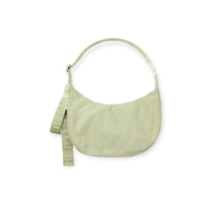 Light sage green crescent-shaped fabric shoulder bag with single strap and decorative branded ribbon detail on white background