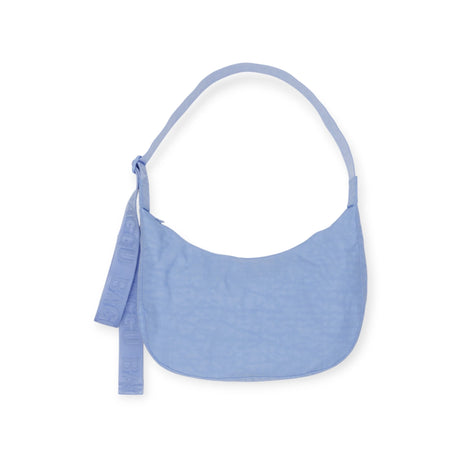 The Baggu Medium Nylon Crescent Bag in French Blue boasts a light blue color, matching strap, and embossed text on fabric, all made from recycled nylon for eco-friendliness.