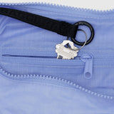 A close-up highlights keys on a black strap atop a recycled nylon light blue zippered pouch. The small zip pocket reveals the elegance and function of the Baggu Medium Nylon Crescent Bag in French Blue.