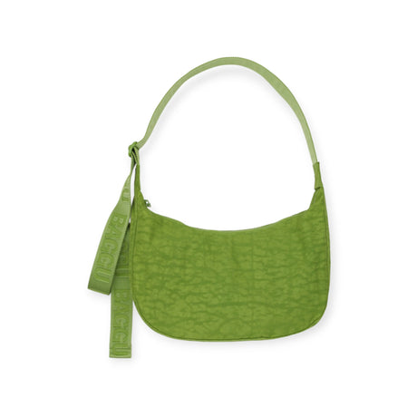 The Baggu Medium Nylon Crescent Bag in Green Juice features a textured surface and strap with "Baggu" on the handle, ideal for eco-conscious fashion lovers.