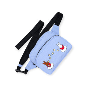 The Miffy x Baggu Fanny Pack by Baggu is a light blue recycled nylon crossbody bag with black adjustable straps, cartoon bunnies, clouds, stars, and "BAGGU" embossed on the strap—perfect for fans of playful style.
