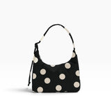 Black mini shoulder bag with cream polka dots and drawstring shoulder strap