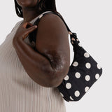 Cream-and-black polka dot mini shoulder bag worn on shoulder