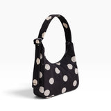 Black mini shoulder bag with cream polka dots and adjustable top strap