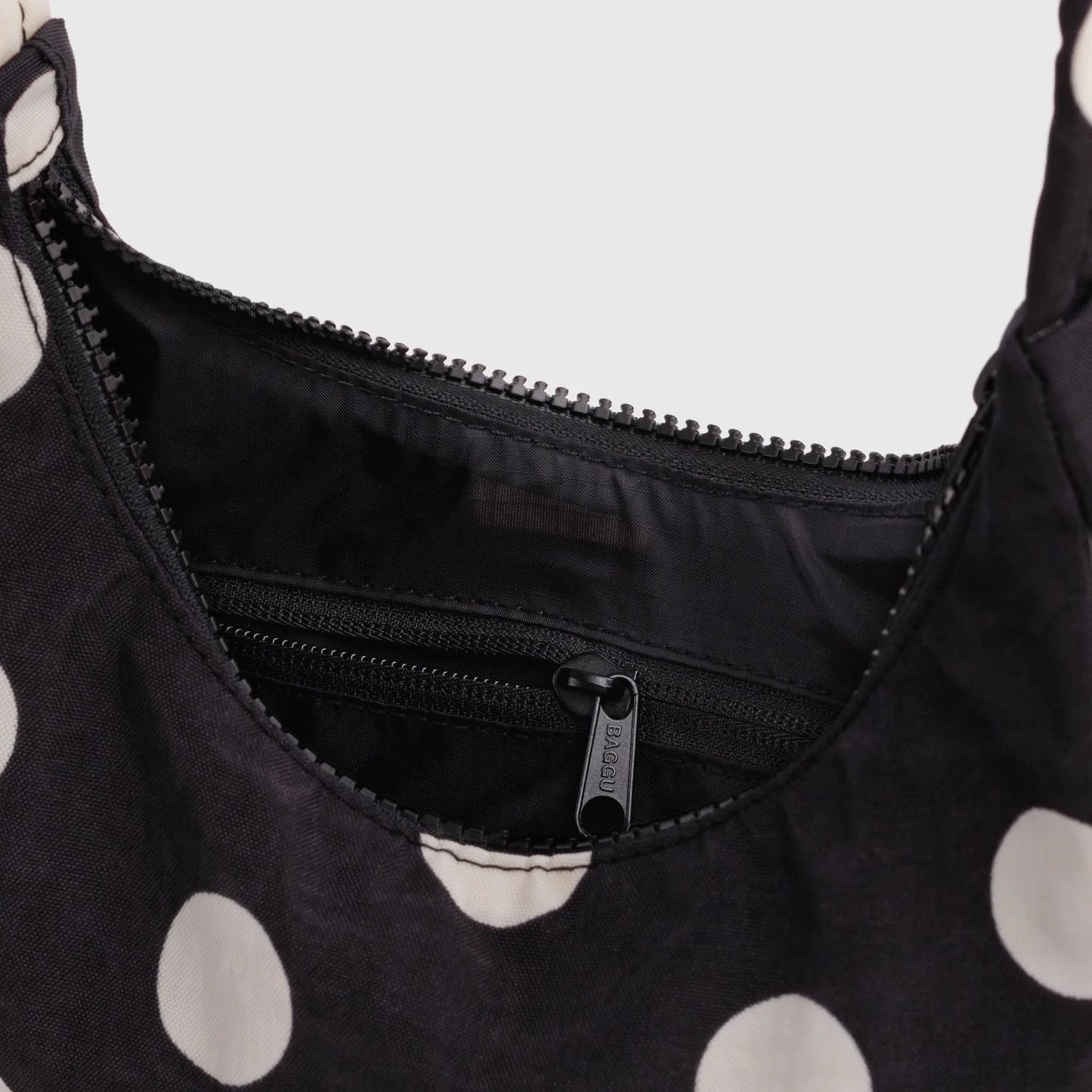 Black nylon mini shoulder bag interior with zipper pocket and zip opening