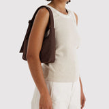 Baggu mini nylon shoulder bag in coffee brown, worn on shoulder with side profile