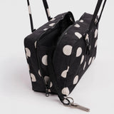 Black nylon bowler bag with cream polka dots, open top showing zippers and key clip.