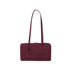 The Baggu Nylon Bowler Bag in mahogany features a rectangular shape, a long shoulder strap, and a zippered closure, showcased against a white background.