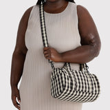 Black-and-cream gingham duffle bag with short handles and crossbody strap