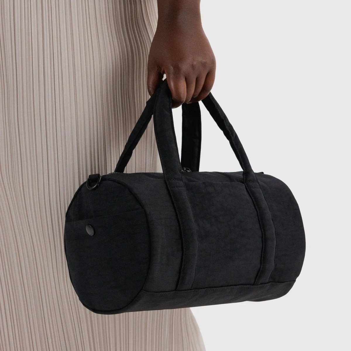 Black nylon duffle bag with rounded end pocket and carry handles