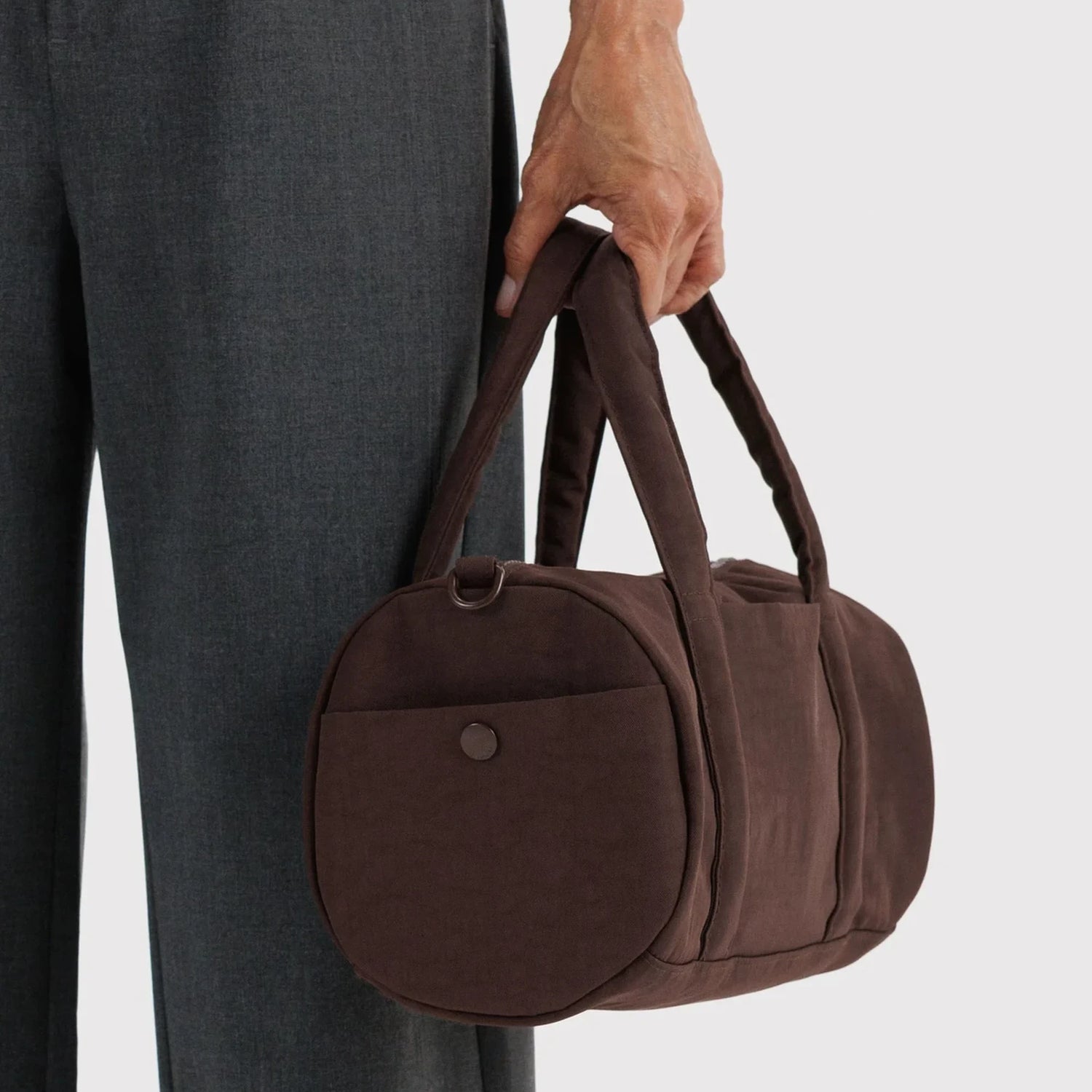 Coffee-brown duffle bag with round front pocket and top handle carry