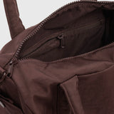Coffee-brown duffle bag interior with zippered pocket and stitched seams