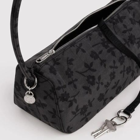 Charcoal nylon bag detail: floral print, metal zipper, key fob on ring