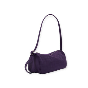 Small deep purple fabric shoulder bag with rounded ends and long strap on white background
