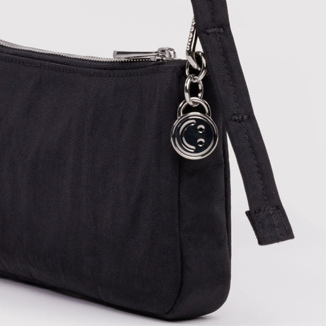 Nylon pochette side view with zipper edge and metal keyring hardware, black