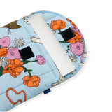 A tablet snugly fits into a vibrant Baggu Puffy Laptop Sleeve 13"/14", distinguished by its Table Cats design, featuring orange, pink, and white flowers on a blue background and crafted from recycled materials.