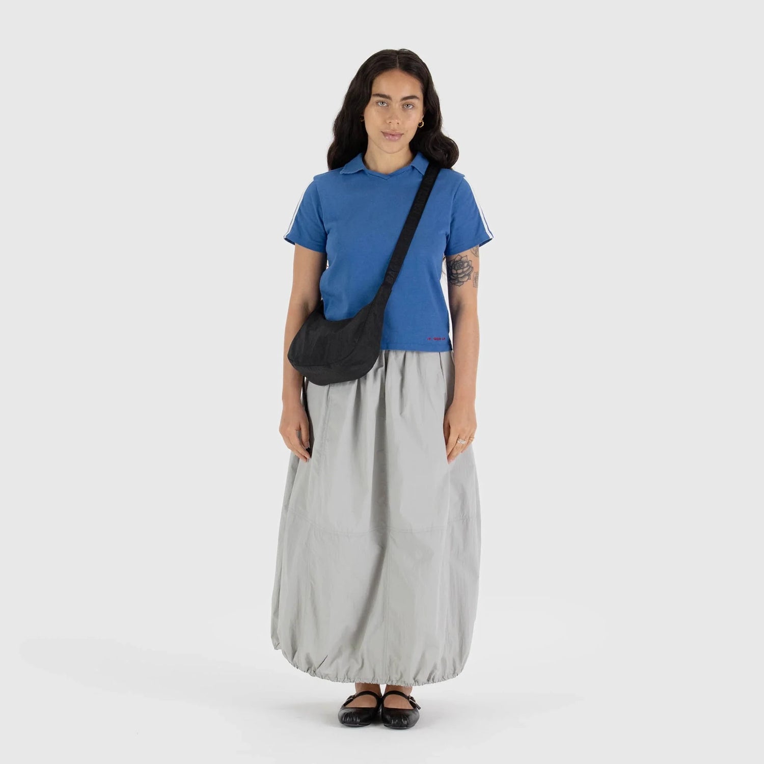 Black crescent shoulder bag worn crossbody with adjustable strap