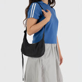 Black crescent shoulder bag with long strap and curved pocket opening